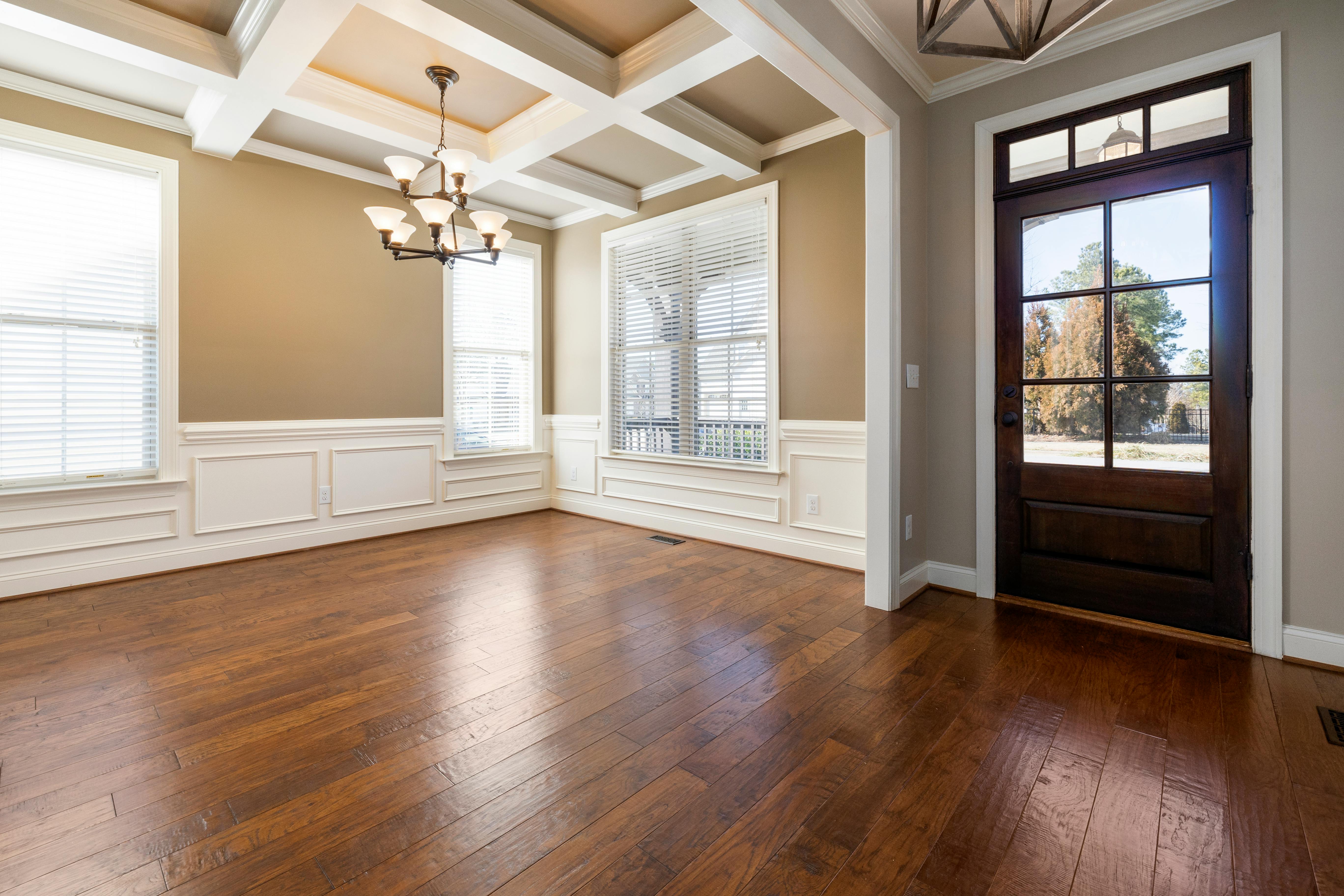 Warm hand-scraped hardwood with coffered ceiling and glass door entry
